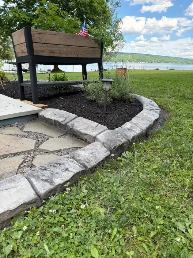 Stamped stone curbing running along a paver walkway and garden border