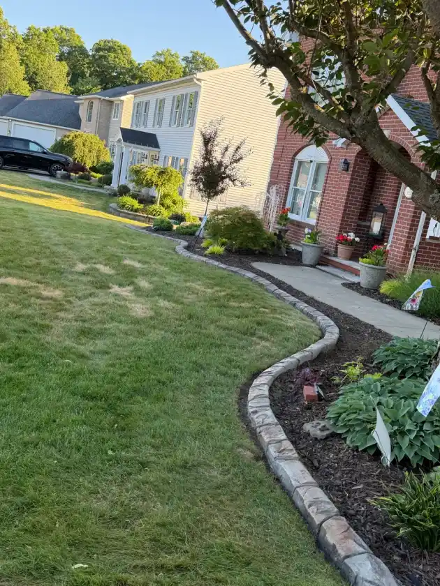 Stamped stone curbing edging a front lawn beside a driveway
