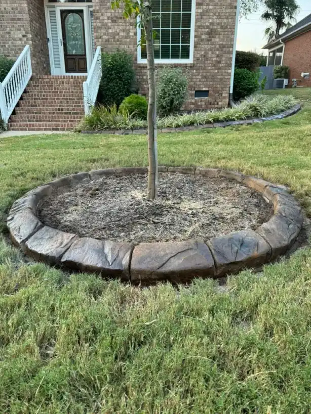 Mower edge curbing along manicured lawn with decorative rock garden